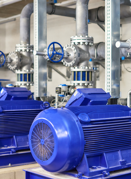 ehrere große blaue Industriemotoren und Ventile in der Pumpstation der Gargellner Bergbahnen. Die Anlage ist Teil des technischen Systems für die Beschneiung der Skipisten. Edelstahlrohre und blaue Steuergriffe verlaufen durch den hellen Technikraum. | © Gargellner Bergbahnen GmbH & Co KG, Stefan Kothner