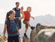 Eine Familie überquert große Felsen in den Bergen von Gargellen. Die Mutter hält die Hand ihres Kindes, während der Vater lächelnd folgt – ein Moment voller Vertrauen und Freude beim Wandern in der Sonne. | © Gargellner Bergbahnen GmbH & Co KG, Daniel Zangerl