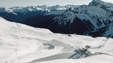 Luftaufnahme der verschneiten Skipisten von Gargellen mit präparierten Abfahrten im Vordergrund. Im Hintergrund sind schneebedeckte Bergketten und das Tal zu sehen. | © Gargellner Bergbahnen GmbH & Co KG, Daniel Zangerl
