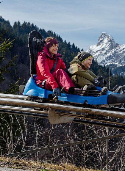Mama mit Kind, welche gerade mit dem Alpine-Coaster-Golm hinunterfahren | © Golm Silvretta Lünersee Tourismus GmbH Bregenz, Philipp Schilcher