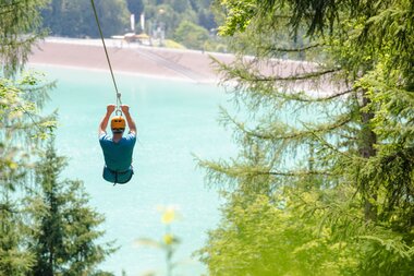 A girl flying over the Latschau reservoir attached to a 565 m long steel cable | © Golm Silvretta Lünersee Tourismus GmbH Bregenz, Stefan Kothner