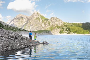 Vater mit Sohn, die gerade am Lünersee fischen | © Golm Silvretta Lünersee Tourismus GmbH Bregenz, Stefan Kothner